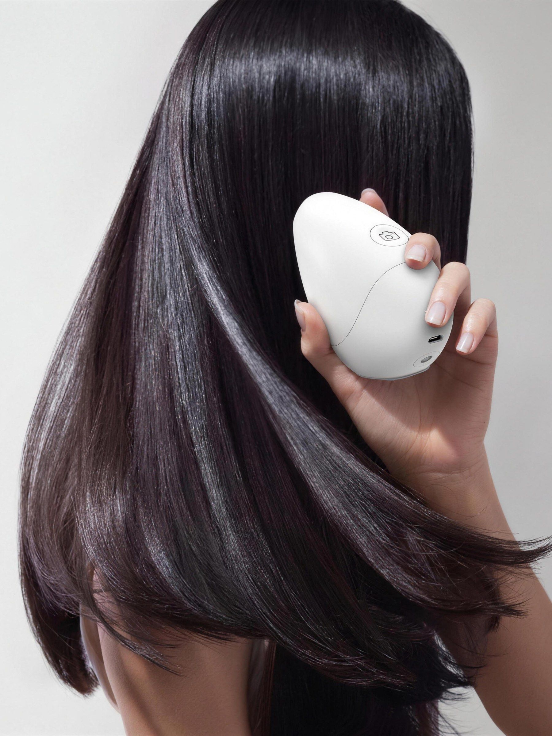 Hand holding a Valid'Or scanner beside long dark hair