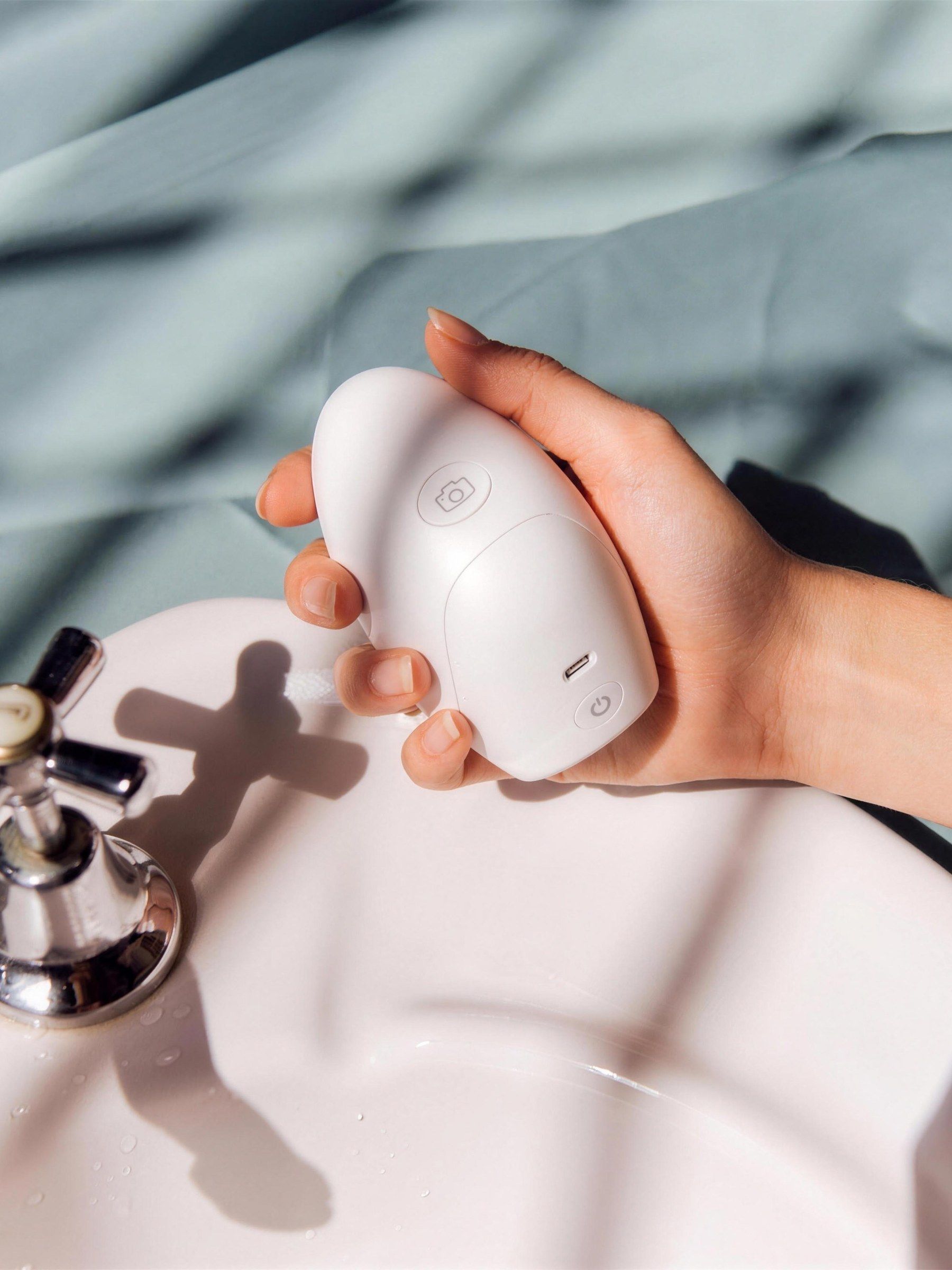 Hand holding a Valid'Or scanner over a bathroom sink